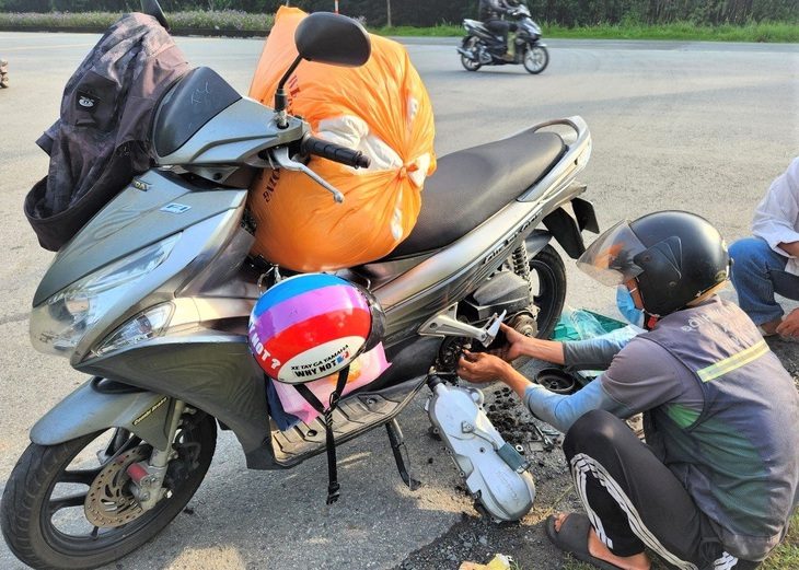 14 năm vá xe lưu động đường rừng - Ảnh 1. Các bạn đội vá xe lưu động Cần Giờ hỗ trợ người đi đường khi gặp sự cố hư hỏng xe - Ảnh: C.K.